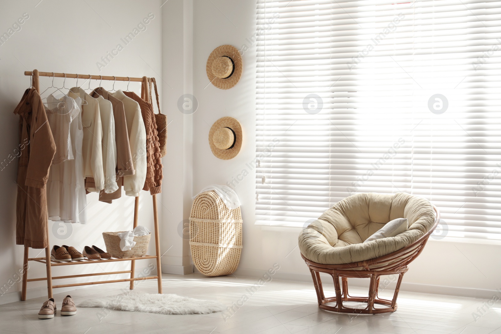 Photo of Modern dressing room interior with rack of stylish women's clothes