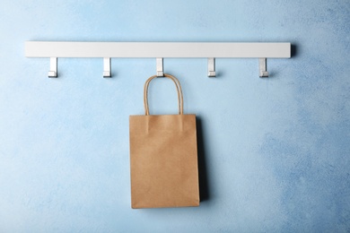 Photo of Rack with paper shopping bag on color wall