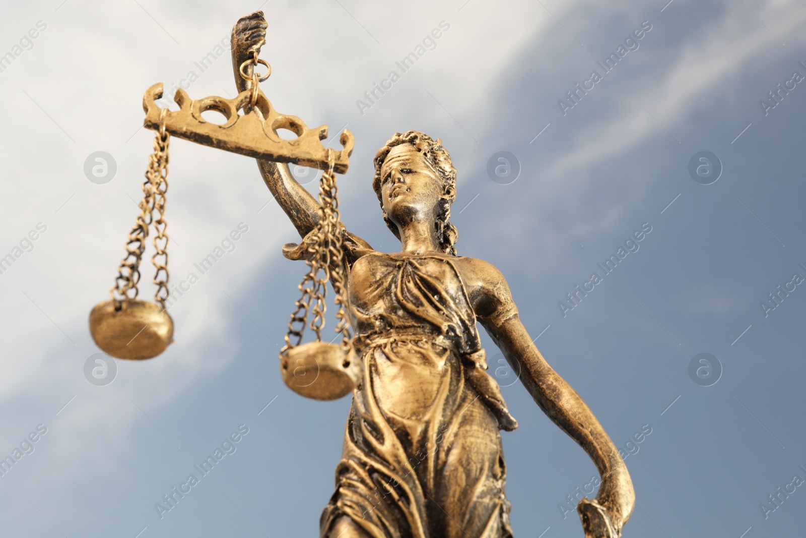 Photo of Figure of Lady Justice against sky, low angle view. Symbol of fair treatment under law