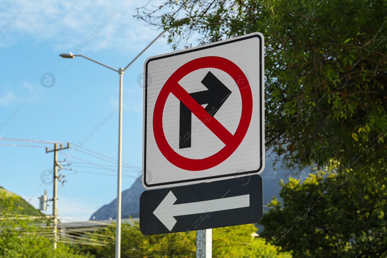 Photo of Different road signs on city street against blue sky