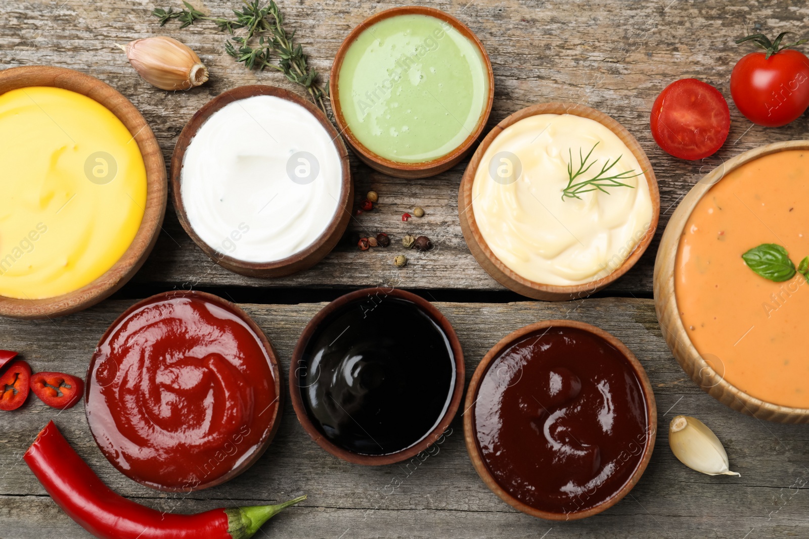 Photo of Many different sauces on wooden table, flat lay