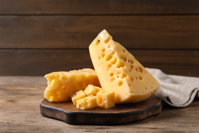 Photo of Pieces of delicious cheese on wooden table