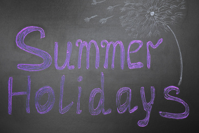 Photo of Phrase SUMMER HOLIDAYS written on black background. School's out