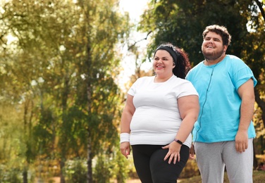 Overweight couple in sportswear together in park