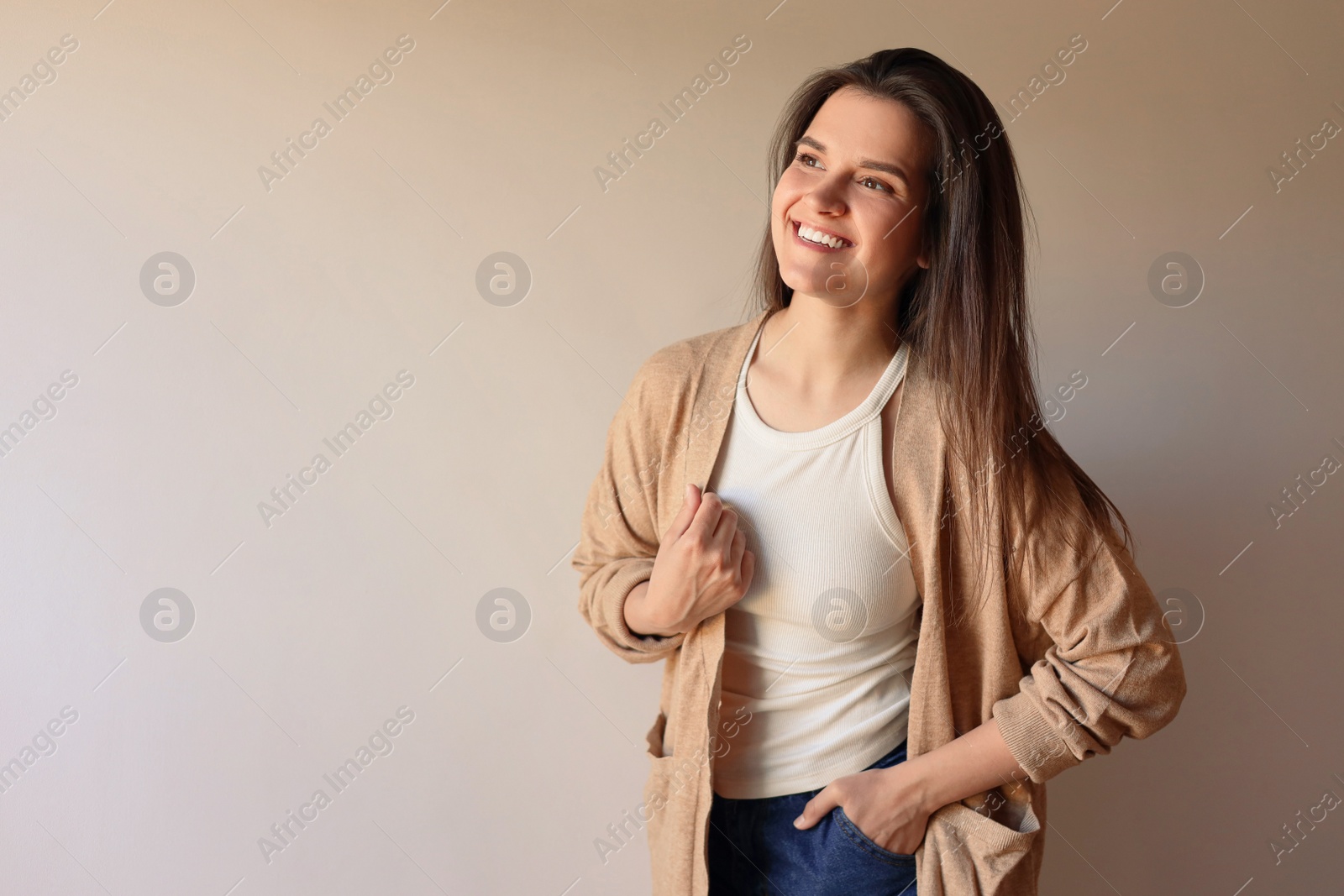 Photo of Portrait of beautiful young woman on beige background, space for text