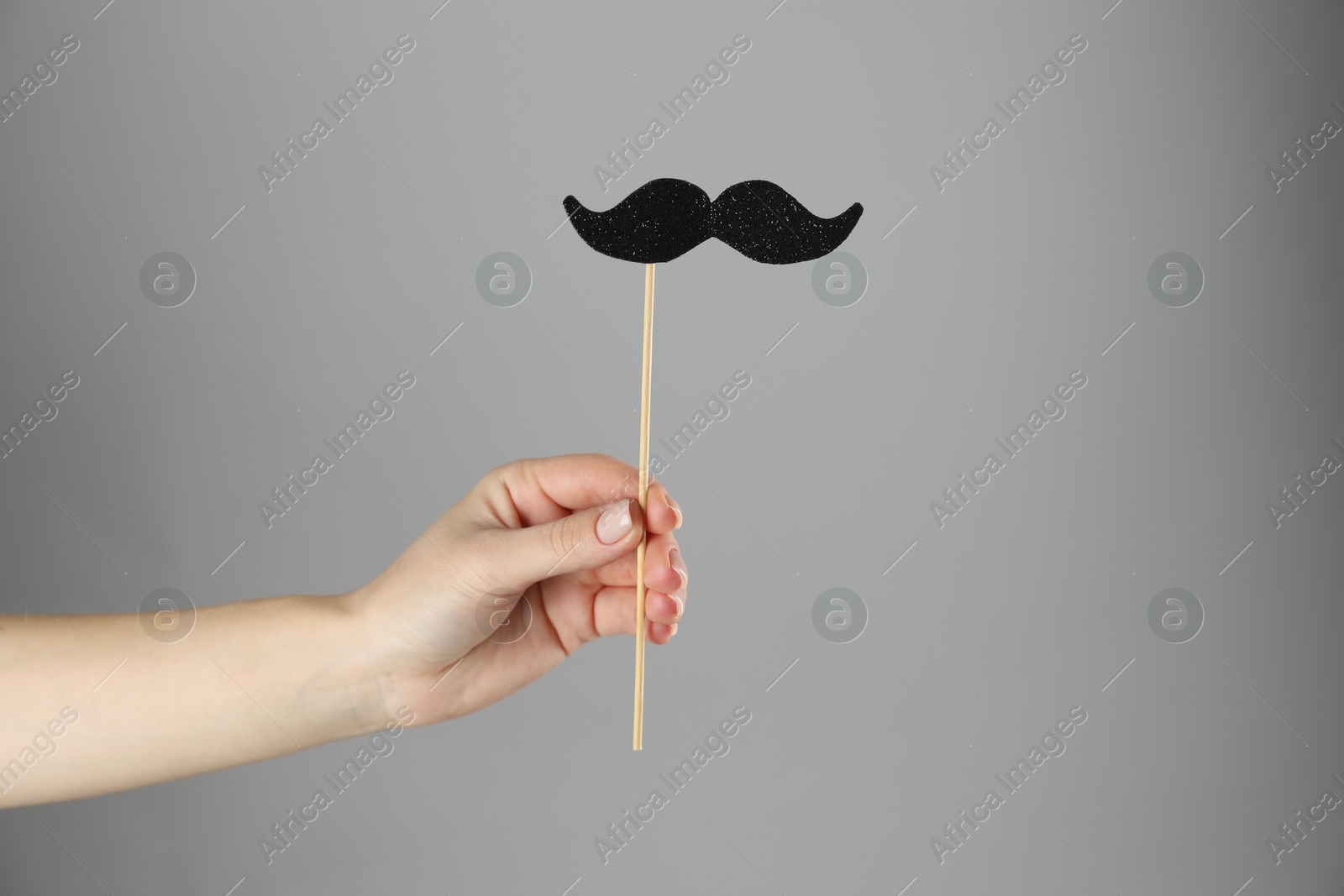 Photo of Woman with fake paper mustache on gray background, closeup. Space for text