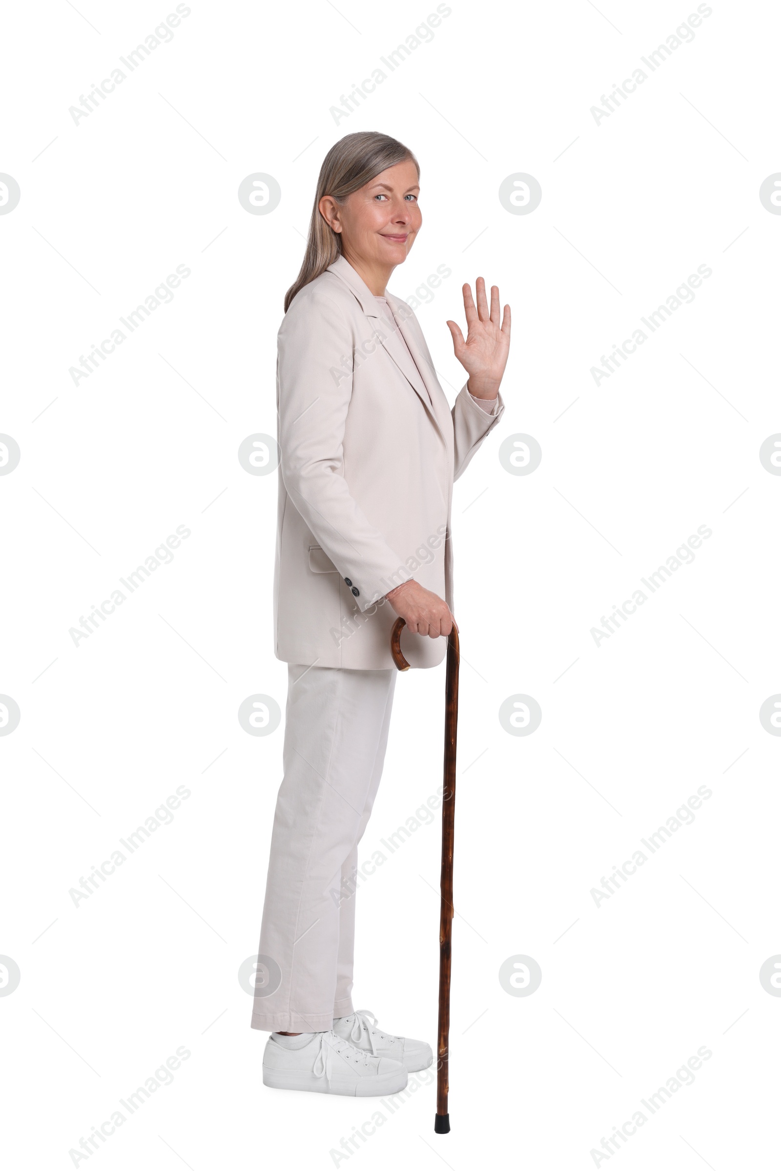 Photo of Senior woman with walking cane waving on white background