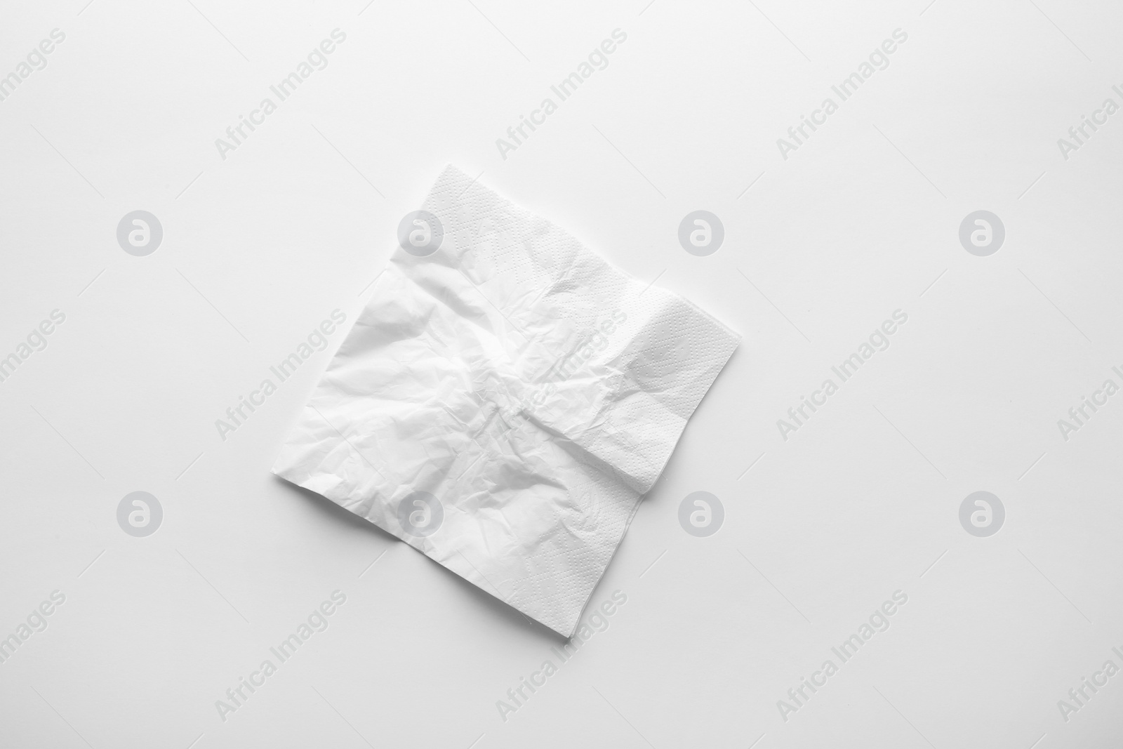 Photo of Crumpled paper napkin on white background, top view