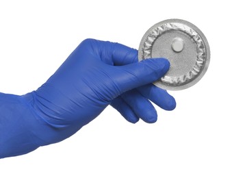 Photo of Doctor holding blister of emergency contraception pill on white background, closeup