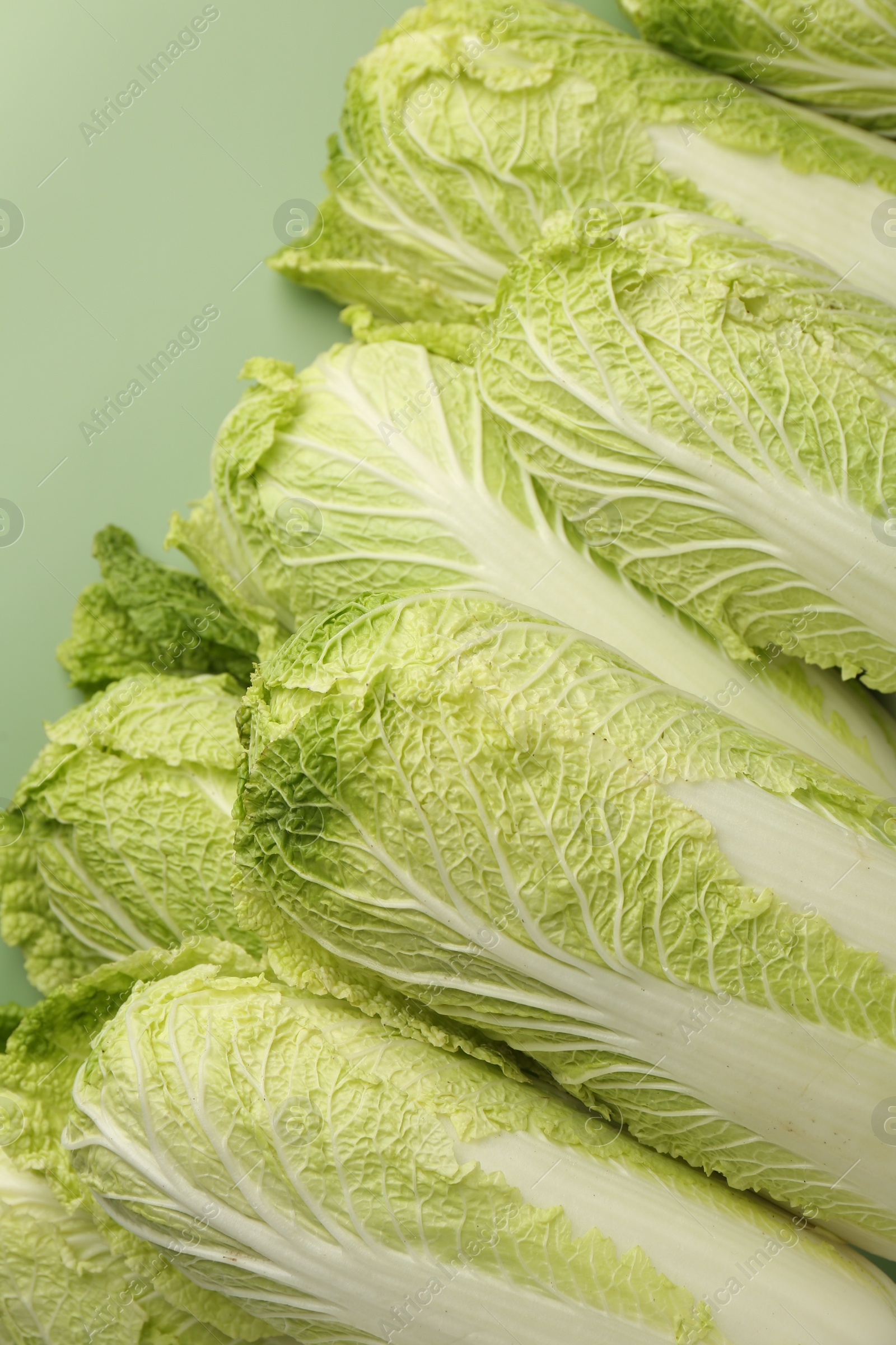 Photo of Fresh ripe Chinese cabbages on pale green background, closeup