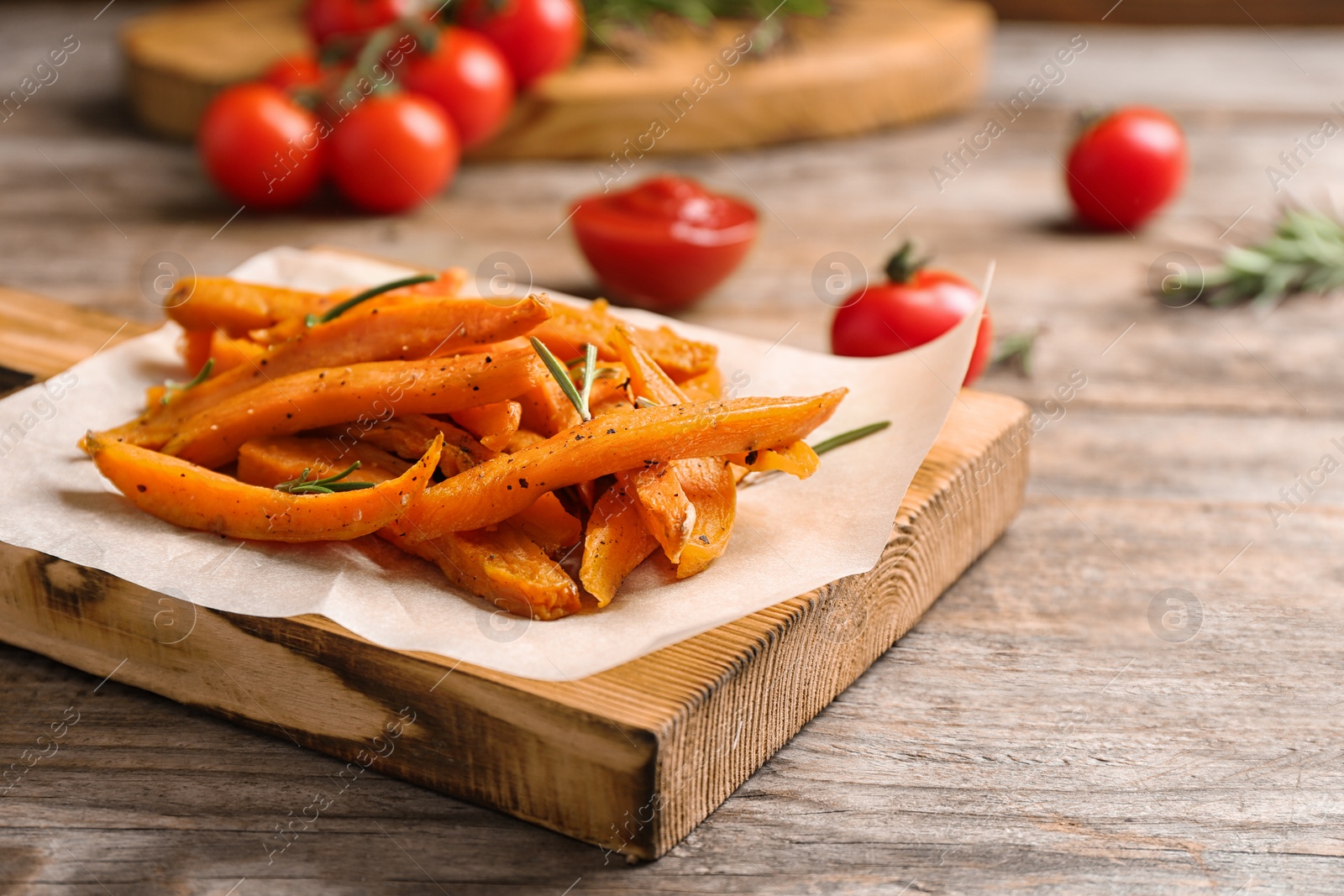 Photo of Board with sweet potato fries on wooden table, closeup. Space for text