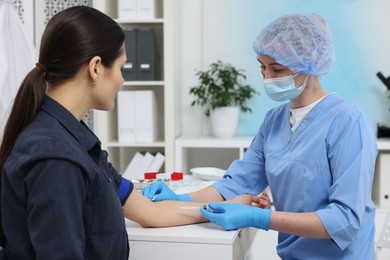 Photo of Laboratory testing. Doctor taking blood sample from patient at white table in hospital