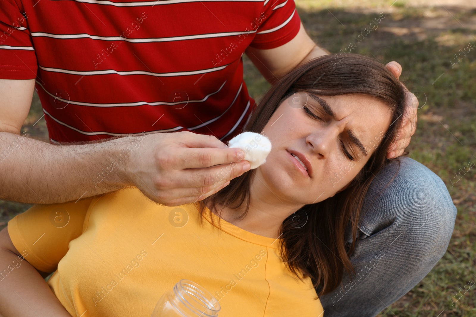 Photo of Man helping woman outdoors. Suffering from heat stroke