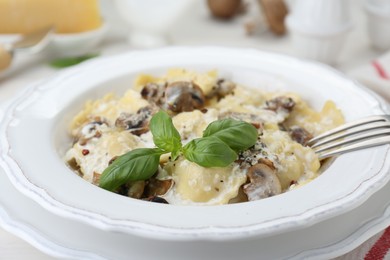 Photo of Delicious ravioli with mushrooms and cheese served on table, closeup