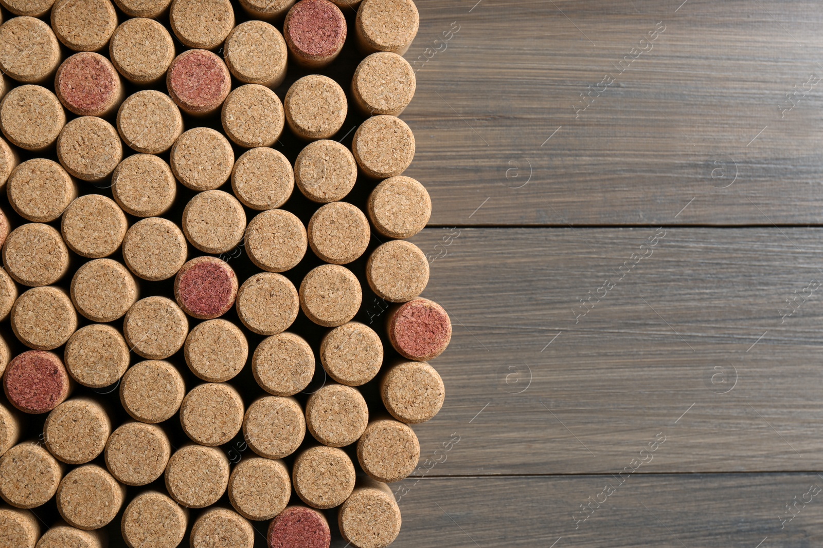 Photo of Flat lay composition with many corks of wine bottles on wooden table. Space for text