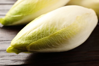 Photo of Raw ripe chicories on wooden table, closeup