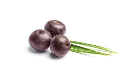 Fresh acai berries with leaves on white background