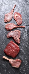 Fresh raw beef cuts on grey textured table, flat lay