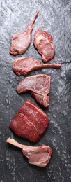 Photo of Fresh raw beef cuts on grey textured table, flat lay