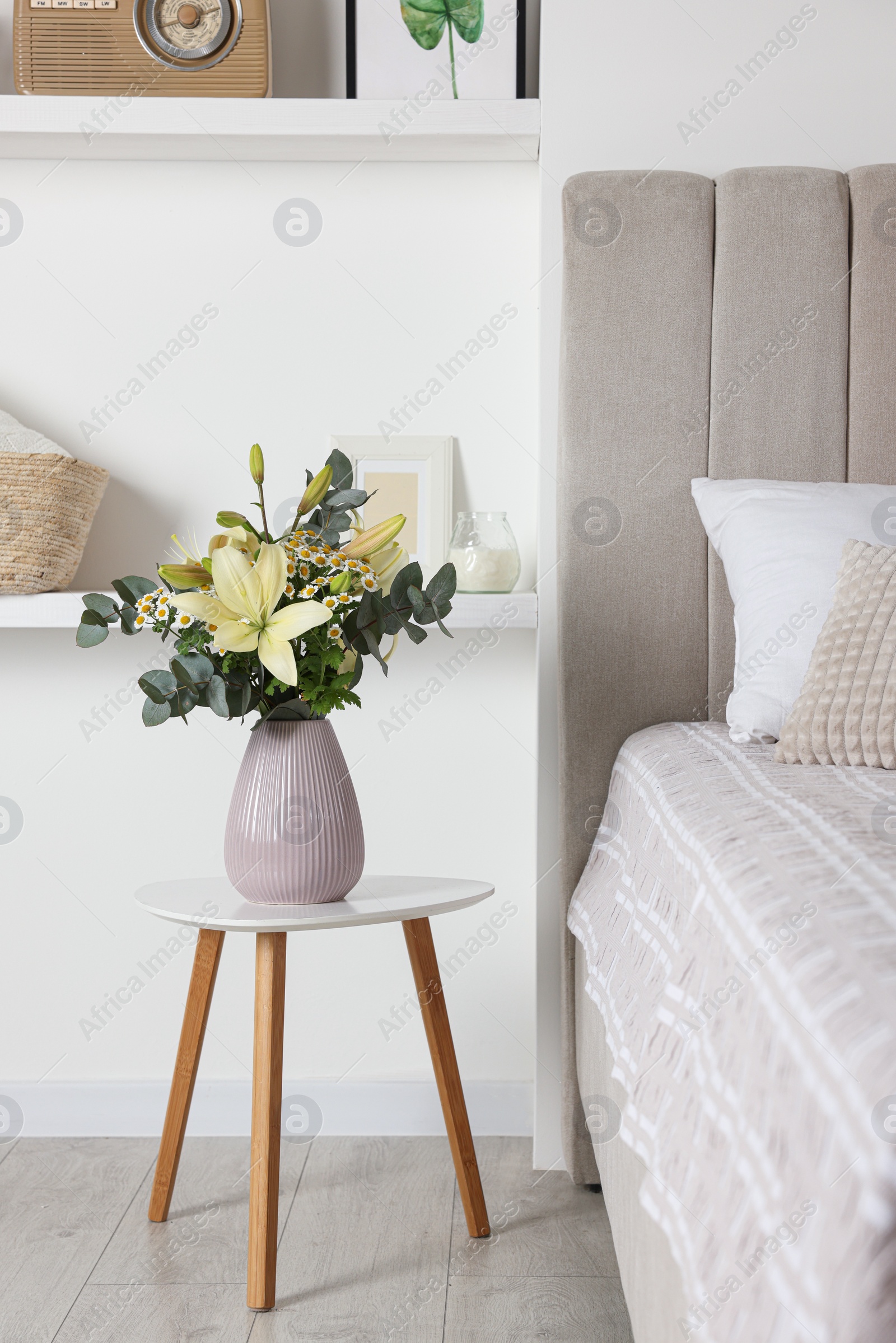 Photo of Bouquet of beautiful flowers on white table in bedroom