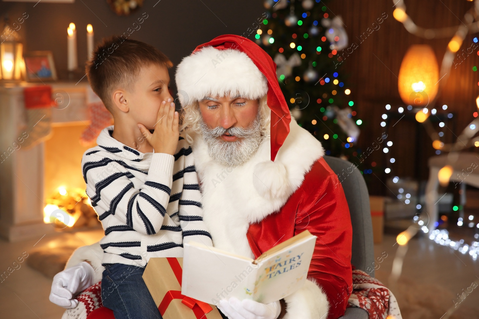 Photo of Little child with Santa Claus at home on Christmas day