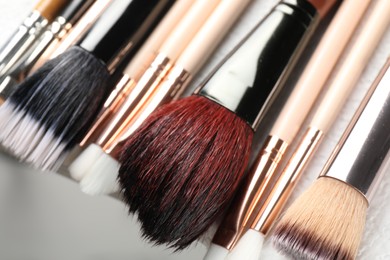 Photo of Set of different makeup brushes drying after cleaning on table, closeup