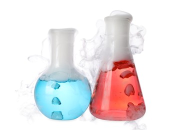 Photo of Laboratory flasks with colorful liquids and steam isolated on white. Chemical reaction