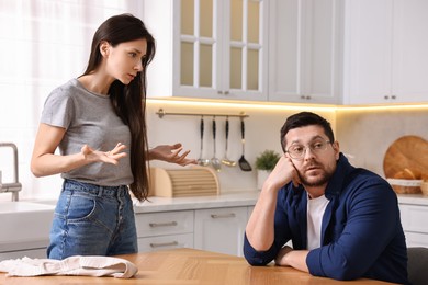 Photo of Annoyed wife blaming her husband in kitchen. Relationship problems