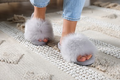 Woman wearing soft slippers at home, closeup of legs