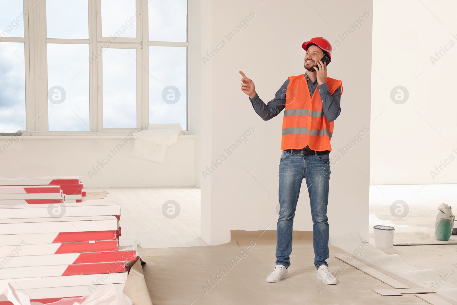 Photo of Male industrial engineer in uniform talking on phone indoors