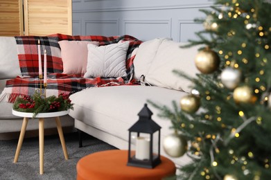 Photo of Christmas decor, lantern with candle and sofa in living room