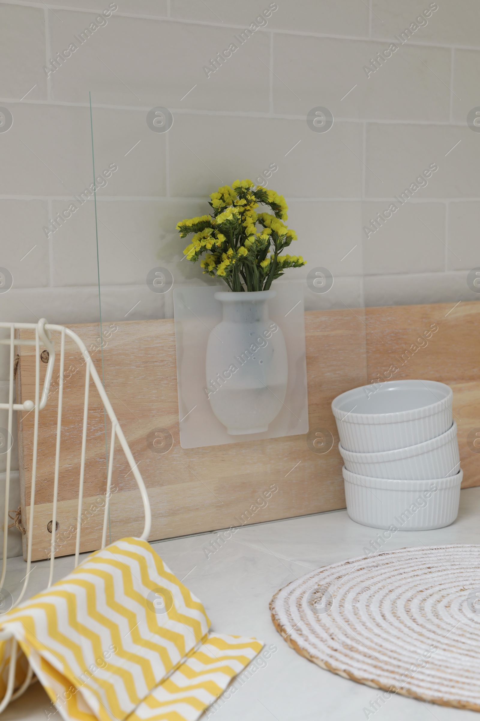 Photo of Silicone vase with flowers on countertop in kitchen