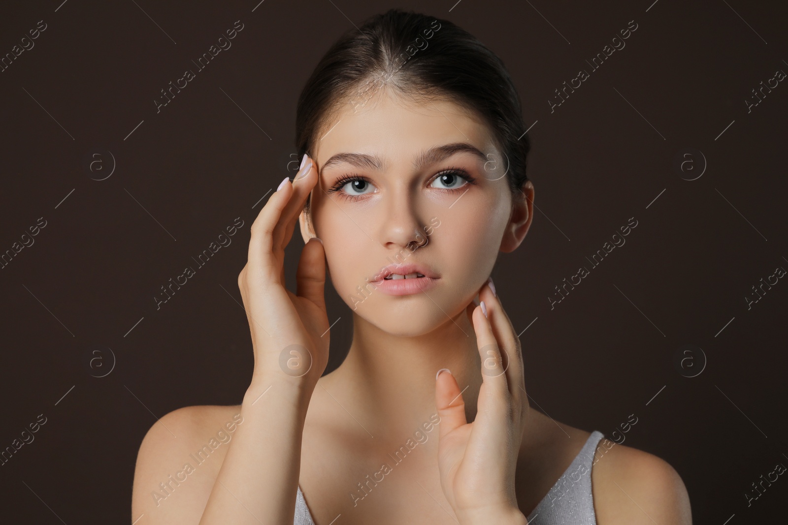 Photo of Portrait of pretty girl on brown background. Beautiful face with perfect smooth skin