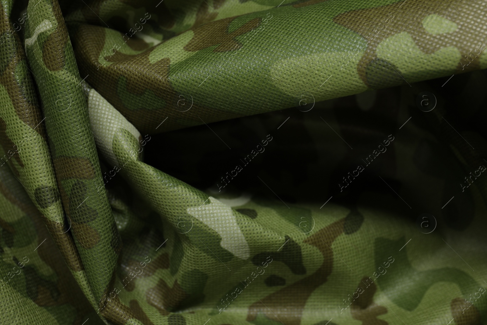 Photo of Texture of crumpled camouflage fabric as background, top view