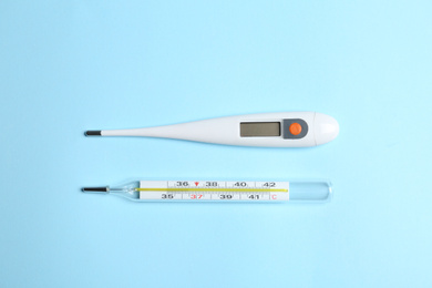 Photo of Different thermometers on light blue background, flat lay