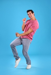 Photo of Handsome young man dancing on blue background