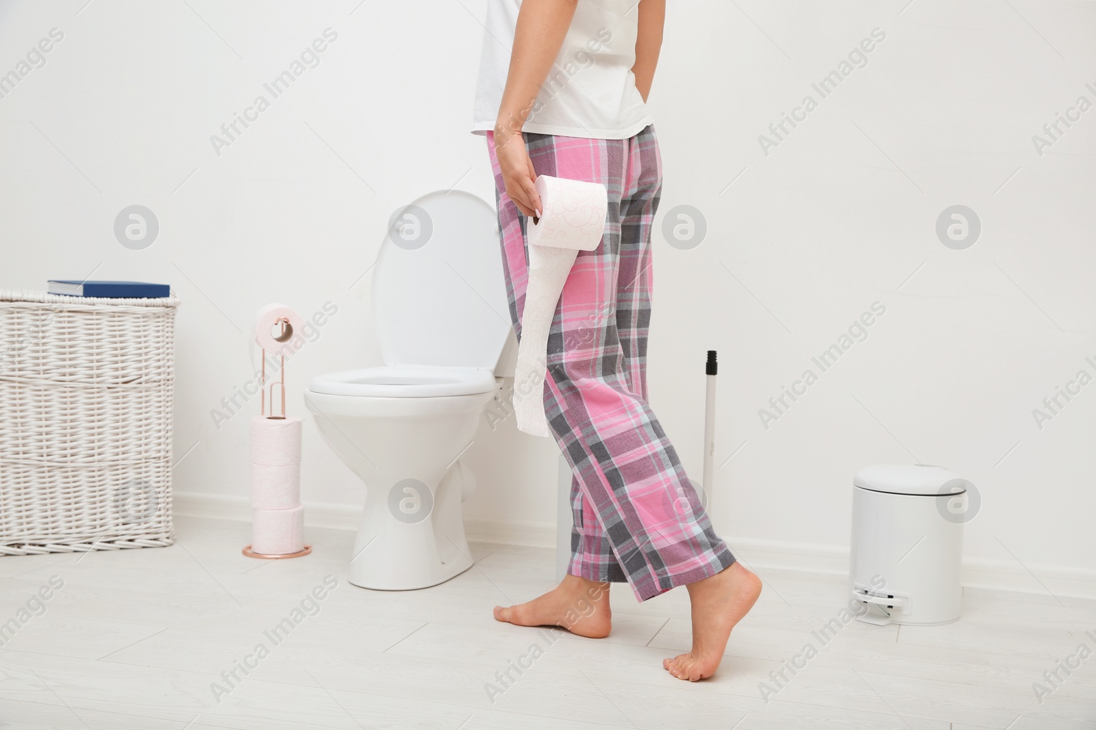 Photo of Woman with toilet paper roll standing in bathroom