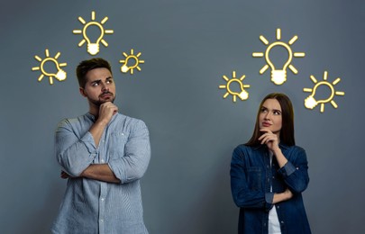 Image of Idea generation. Thoughtful man and woman on grey background. Illustrations of light bulb over them