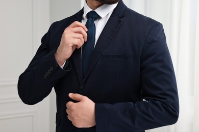 Businessman in suit and necktie indoors, closeup