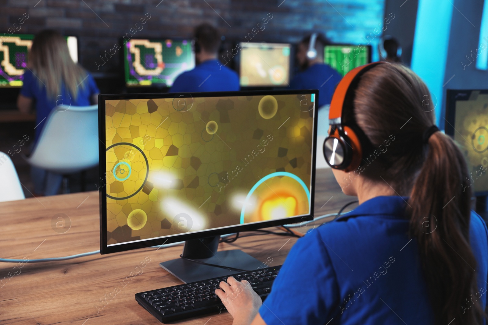 Photo of Woman playing video game in internet cafe