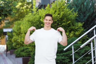 Photo of Young man in white t-shirt outdoors. Mockup for design