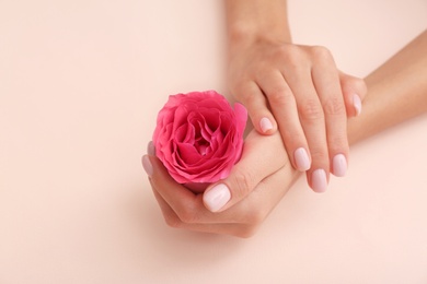 Closeup view of woman with rose on color background, space for text. Spa treatment