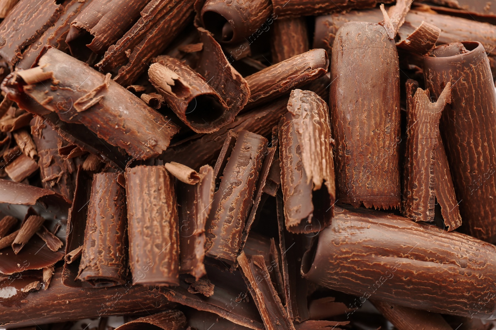 Photo of Delicious milk chocolate curls as background