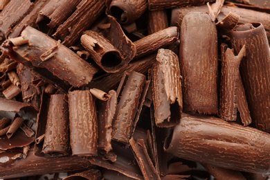 Photo of Delicious milk chocolate curls as background