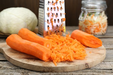 Cooking delicious sauerkraut soup. Fresh chopped carrot on wooden table, closeup