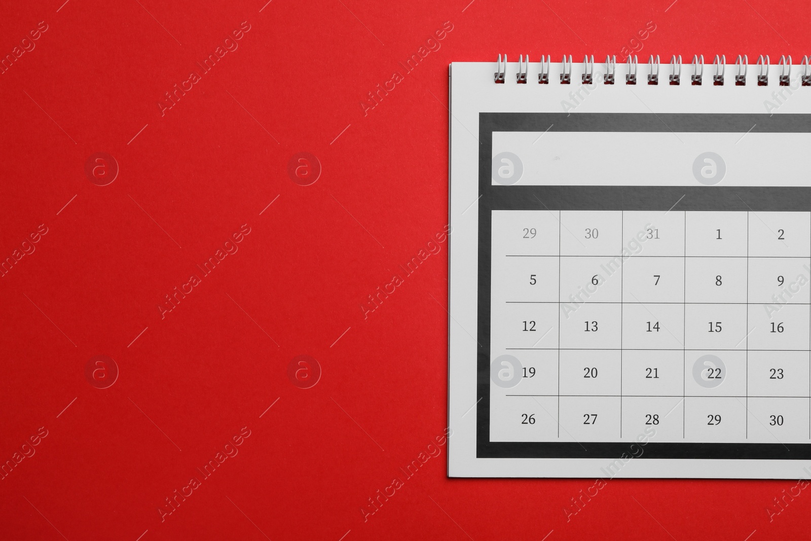 Photo of Paper calendar on red background, top view. Space for text