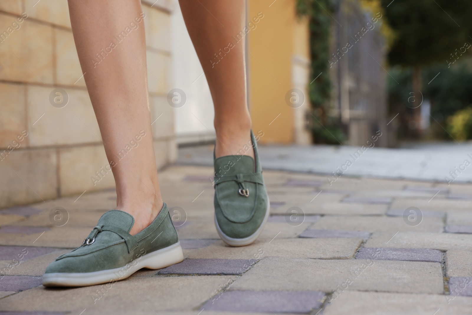 Photo of Woman in stylish loafers walking on city street, closeup