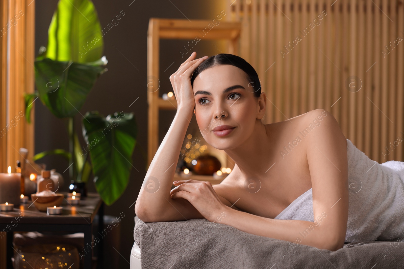 Photo of Spa therapy. Beautiful young woman lying on massage table in salon, space for text