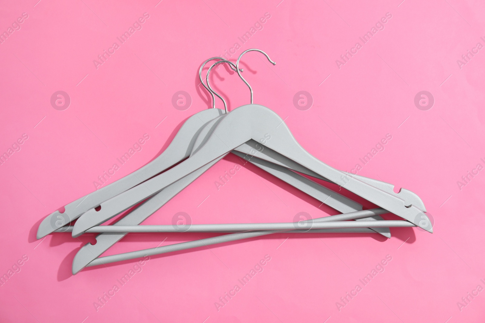 Photo of Flat lay composition with empty hangers on color background