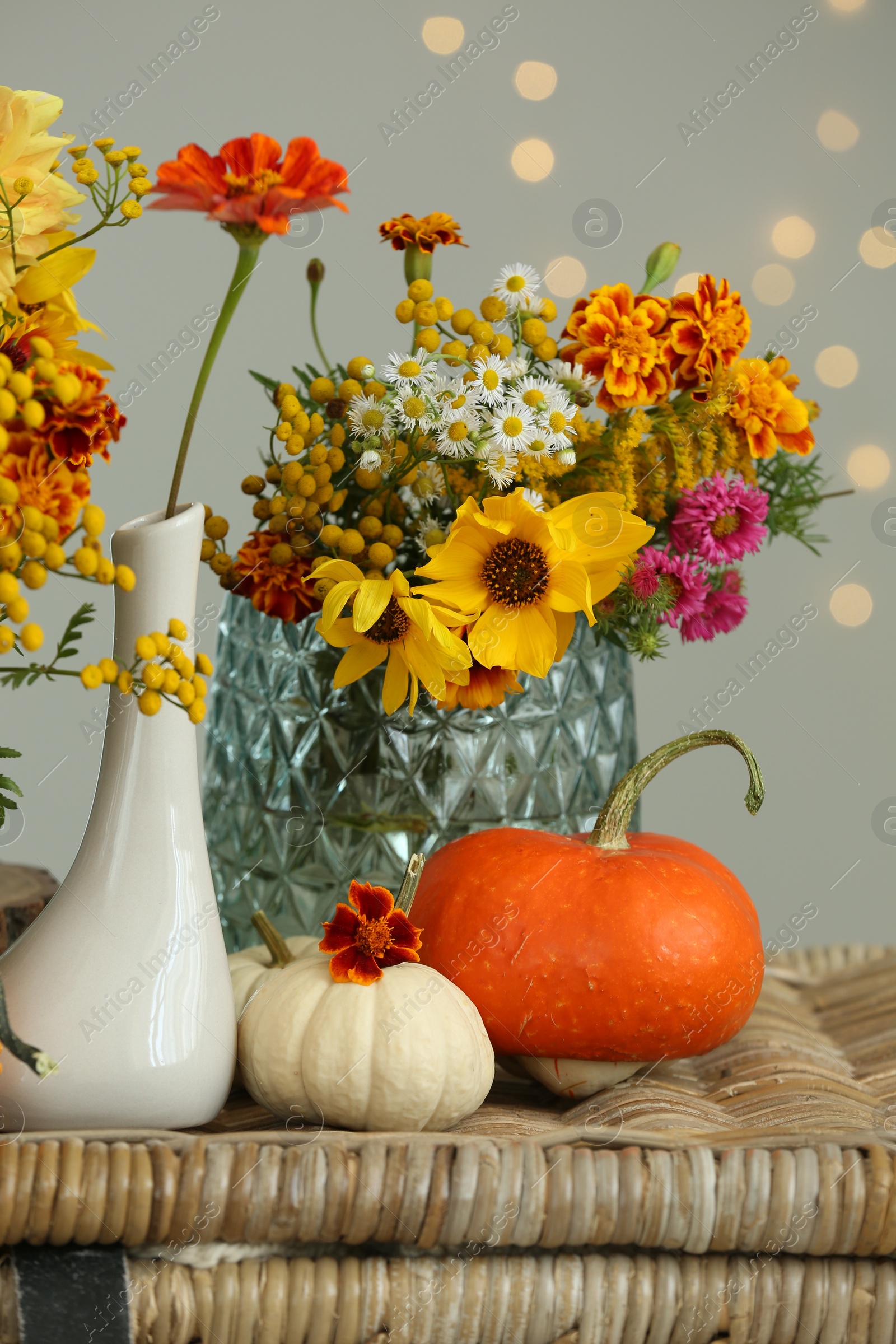 Photo of Beautiful autumn composition with pumpkins and flowers on wicker table